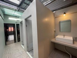 ein Badezimmer mit Waschbecken und einem Fernseher an der Wand in der Unterkunft Comfort Zone Hostel @ Tha Pae in Chiang Mai