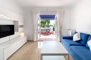 a living room with a blue couch and a tv at Las Palmas 2a Oasis Properties in Nerja