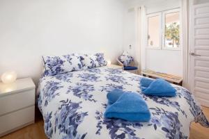 a bedroom with a blue and white bed with towels on it at Las Palmas 2a Oasis Properties in Nerja