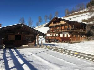 a large wooden building with snow on the ground at Sonnenglück Chalet WILD272 in Wildschönau