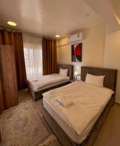 1 Schlafzimmer mit 2 Betten und einem Fenster in der Unterkunft Alhamra Horizons in Al Hamra
