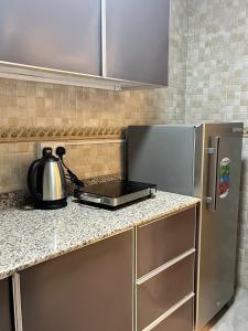 a kitchen with a counter top with a refrigerator at Alhamra Horizons in Al Ḩamrāʼ