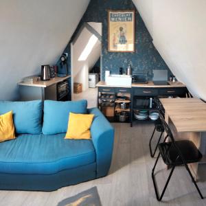 ein blaues Sofa mit gelben Kissen im Wohnzimmer in der Unterkunft Le grenier de Mamou in Hesdigneul-lès-Boulogne