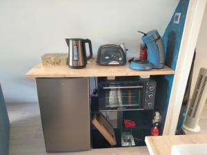 a table with a coffee maker and a microwave on it at Le grenier de Mamou in Hesdigneul-lès-Boulogne +18 photos