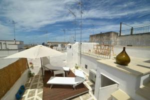 a patio with a white umbrella and a vase on a roof at Silvia House - Vb Vacanze Ostuni in Ostuni