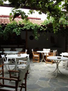an outdoor patio with tables and chairs and areens at Hotel Hellinikon in Ouranoupoli
