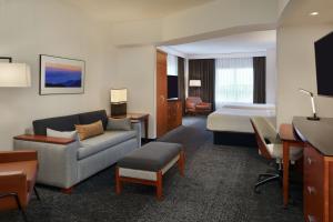 a hotel room with a bed and a couch at Courtyard by Marriott Calgary Airport in Calgary