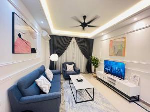 a living room with a blue couch and a tv at R&F PRINCESS COVE at ANJU in Johor Bahru