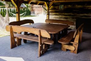 drewniany stół piknikowy i ławki w kabinie w obiekcie Przystań Roztocze, nowoczesny dom z sauną i jacuzzi w mieście Susiec