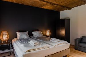 sypialnia z dużym łóżkiem z czarną ścianą w obiekcie Przystań Roztocze, nowoczesny dom z sauną i jacuzzi w mieście Susiec