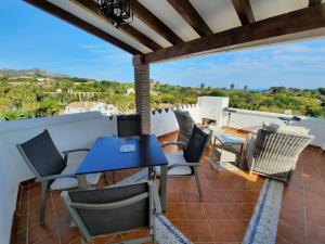 a patio with a blue table and chairs on a roof at Las Palmas 15C Oasis Properties in Nerja