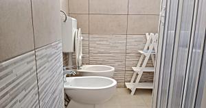 een badkamer met 2 toiletten en een wastafel bij COLOMBO casa per vacanze in corte salentina in Matino
