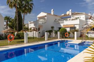 a villa with a swimming pool in front of a house at Las Palmas 15C Oasis Properties in Nerja