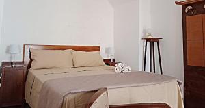 マティーノにあるCOLOMBO casa per vacanze in corte salentinaのベッドルーム1室(大型ベッド1台、ナイトスタンド2台、ランプ2つ付)