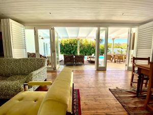 a living room with a couch and a table and chairs at The Burrow in Tulbagh