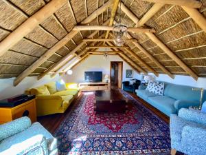 a living room with blue couches and a rug at The Burrow in Tulbagh