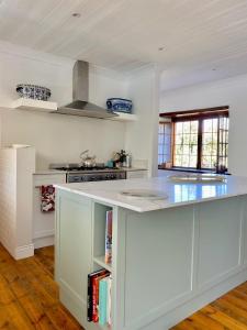 a kitchen with a white counter top with books at The Burrow in Tulbagh