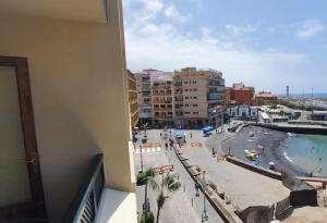een balkon met uitzicht op een zwembad en een stad bij Mirador del Atlántico - Aptos Tosca in Puerto de la Cruz
