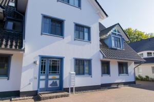 ツィングストにあるFerienwohnung Meeresrauschenの白い家(青いドア、窓付)