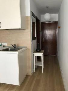 een keuken met een wastafel en een houten vloer bij Mirador del Atlántico - Aptos Tosca in Puerto de la Cruz +3 foto's