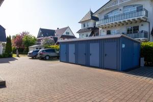 ein Gebäude mit einer blauen Garage neben einem Haus in der Unterkunft Ferienwohnung Meeresrauschen in Zingst