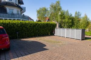 ein Auto, das in einer Einfahrt neben einer Hecke parkt in der Unterkunft Ferienwohnung Meeresrauschen in Zingst