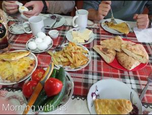 a table with plates of food and plates of food at Shorena's Homestay in Tsvirmi
