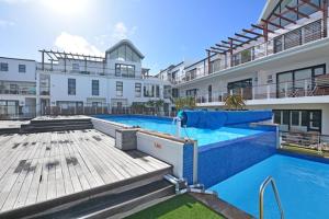 a large swimming pool in front of a building at Luxury Beachfront Apartment in Big Bay- 2 bedroom in Bloubergstrand
