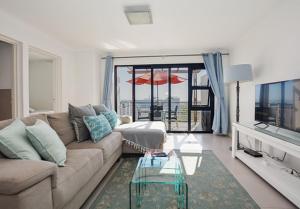 a living room with a couch and a glass table at Luxury Beachfront Apartment in Big Bay- 2 bedroom in Bloubergstrand