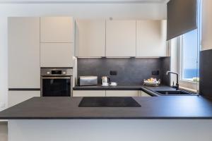 a kitchen with white cabinets and a black counter top at Seaside Luxury in Pembroke St Julians in Pembroke 