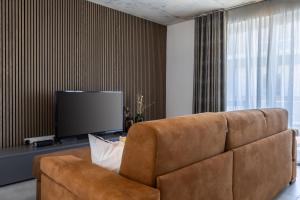 a living room with a brown couch and a flat screen tv at Seaside Luxury in Pembroke St Julians in Pembroke 