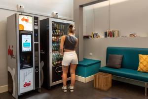 a woman standing in front of a vending machine at Plus Florence in Florence