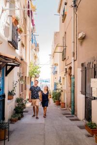 een man en een vrouw die in een steegje lopen bij Le calme à deux pas du port de Sète in Sète