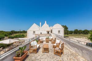 a balcony with chairs and tables on a building at Masseria Nicola Casavola in Martina Franca
