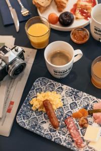 een tafel met een bord eten en een kopje koffie bij Kyriad Metz Centre - Restaurant Moze in Metz