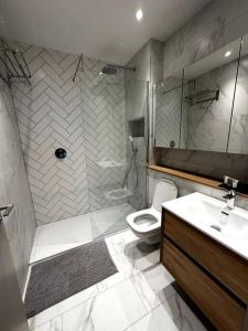 a bathroom with a shower and a toilet and a sink at Stunning 2BR Apt in Central Manc in Manchester