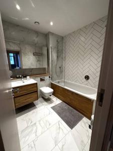 a bathroom with a tub and a toilet and a sink at Stunning 2BR Apt in Central Manc in Manchester