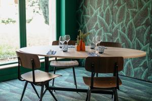 a table in a room with a green wall at Kyriad Metz Centre - Restaurant Moze in Metz