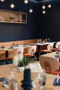 un comedor con mesas, sillas y luces en Kyriad Metz Centre - Restaurant Moze, en Metz