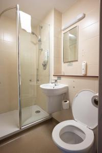 La salle de bains est pourvue de toilettes, d'un lavabo et d'une douche. dans l'établissement Wellington Hotel by Greene King Inns, à Aberdeen