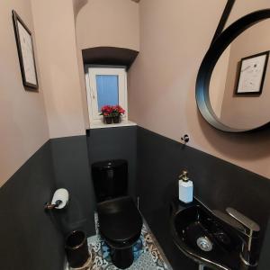 a bathroom with a black toilet and a sink at HOME in BLACK, designer decorated in Zagreb