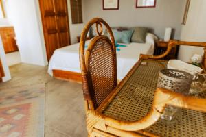 a room with a wooden chair and a bed at Le Morne Vista in Le Morne