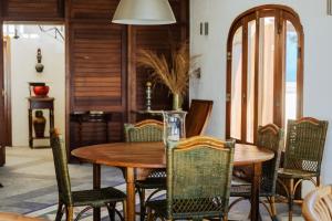 Le Morne Vista في لو مورن: غرفة طعام مع طاولة وكراسي خشبية