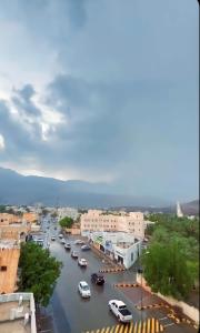 une ville avec des voitures garées dans une rue avec de l'eau dans l'établissement Alhamra Horizons, à Al Hamra