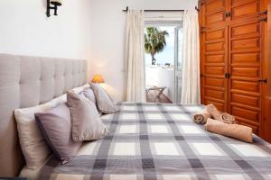 1 dormitorio con 1 cama grande con manta a cuadros en Tetuan 11 Oasis Properties, en Nerja