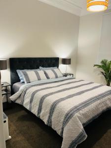 a bedroom with a large bed with a black headboard at Luxurious Home Close to Beach in Dunedin