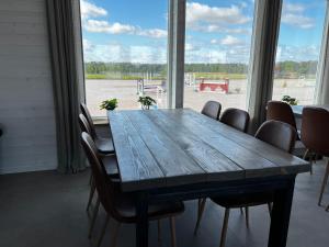 einen Esstisch mit Stühlen und ein großes Fenster in der Unterkunft Hallands Equestrian Center in Laholm
