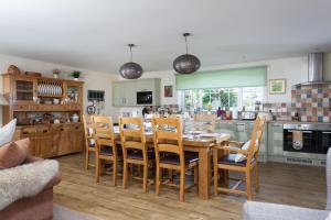 a kitchen and dining room with a table and chairs at Holywell House 8 Guests in Wellington