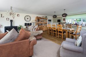 ein Wohnzimmer mit 2 Sofas und einem Esszimmer in der Unterkunft Holywell House 8 Guests in Wellington