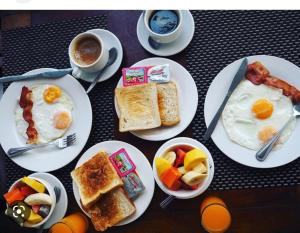 a table with plates of breakfast foods and cups of coffee at Villa Phonethip Mekong Riverside in Luang Prabang